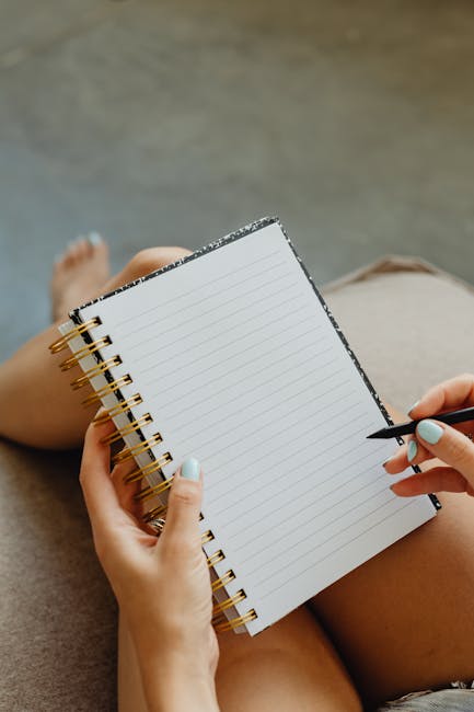 Hands holding a pen and notebook, ready to write